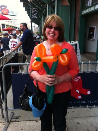 woman standing outside Fenway park with balloon flowers