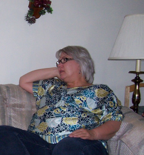 picture of overweight woman sitting on couch in blue and yellow shirt