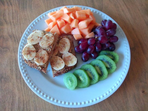 plate of canteloupe, grapes, kiwi, and bananas on toast