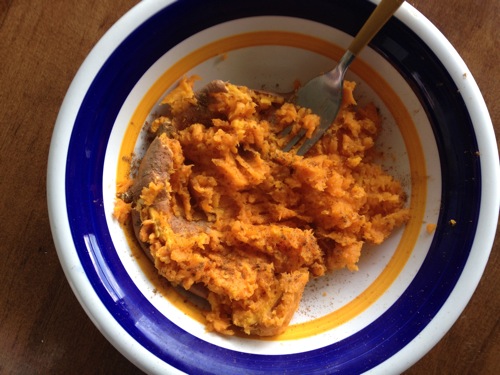 mashed sweet potato in a bowl sprinkled with pumpkin pie spice