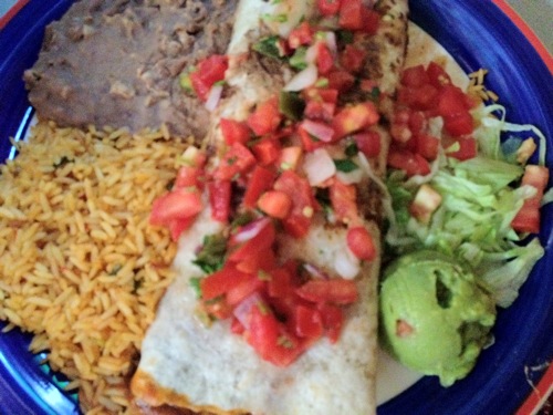 vegetable enchilada with a side of beans and rice
